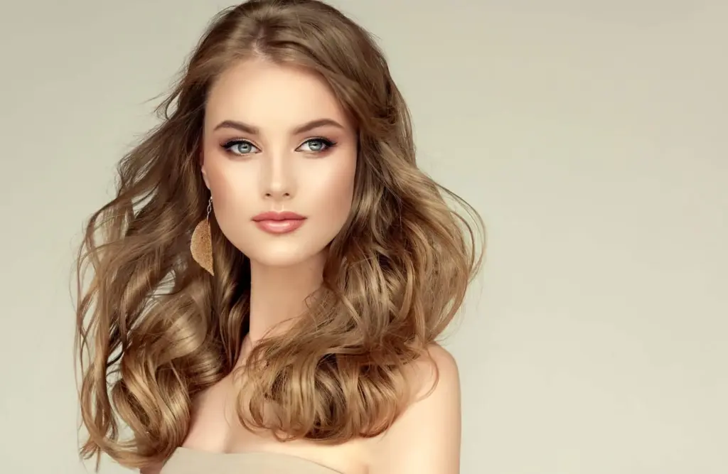 a woman with long hair and a gold earring