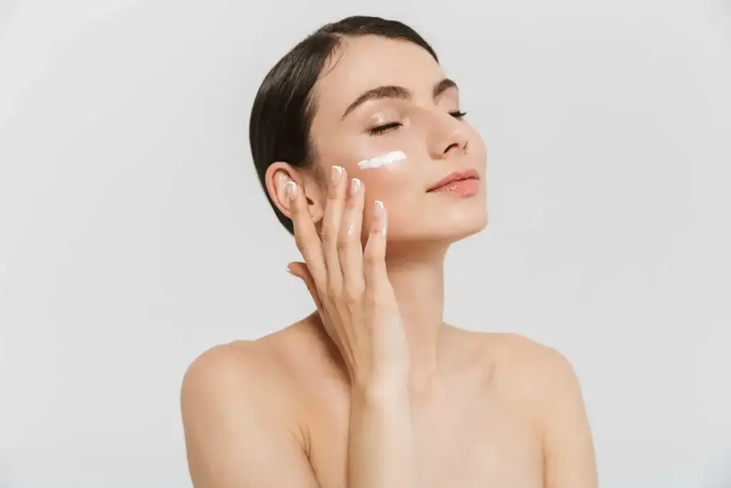 a woman applying cream on her face